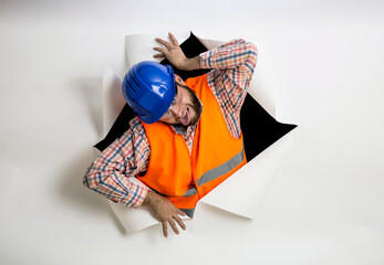 builder man coming out of torn paper wall - 615269541