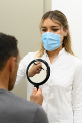 Female cosmetologist examining patient in clinic