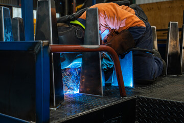 Man welding in industrial space for Engineering blue spark
