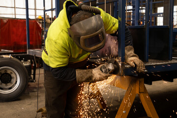 Man using grinder in Industrial Space for Engineering