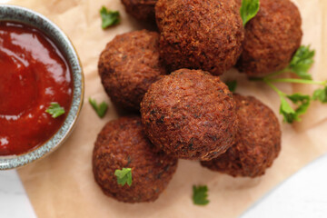 Vegan meat products. Delicious falafel balls, parsley and sauce on table, flat lay