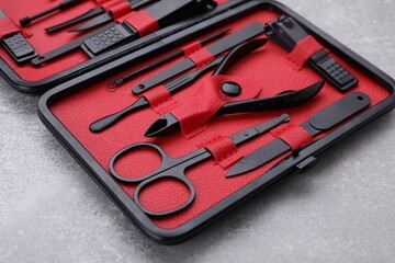 Kit of pedicure tools on light gray table, closeup