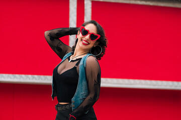 retrato de bella mujer latina sonriendo con maquillaje jugando con sus lentes rojos al aire libre...