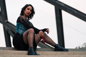 bella mujer latina posando en la calle en estructuras metálicas, estilo 80s 90s en un parque al...