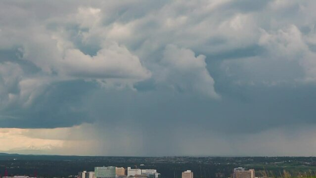 Huge dark hurricane stormy clouds gettering above a city, panoramic view of storm cloudscape at the horizontal. The astonishing scenery of the sky in the summer season. The rainy weather forecasting.