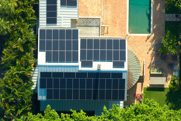 Aerial view of expensive american home roof with blue solar photovoltaic panels for producing clean...