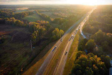View from above of busy american highway with fast moving traffic between autumn woods. Interstate...