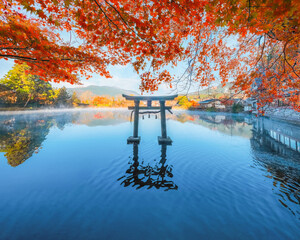 Yufuin, Japan - Nov 27 2022: Tenso-jinja shrine at lake Kinrin, is one of the representative sightseeing spots in the Yufuin area at the foot of Mount Yufu. - obrazy, fototapety, plakaty