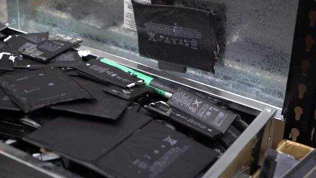 Opening A Box Of Used Phone Batteries With A Pan