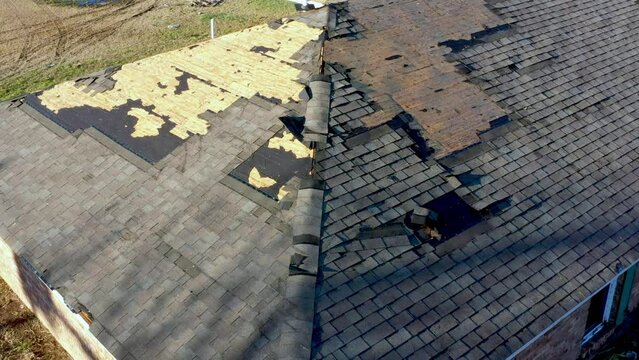 Tornado damage to roof with missing shingles, in need of repair