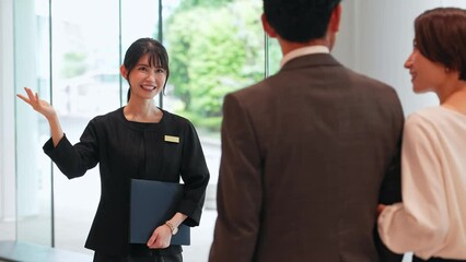 A guide in the lobby. Guests being guided at the front desk of the hotel.