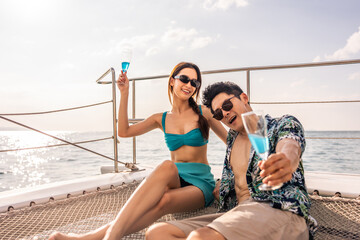 Asian beautiful couple drinking champagne while having party in yacht. 