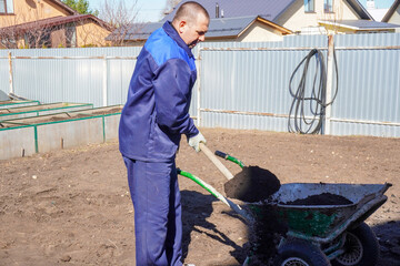 A man works in a vegetable garden in early spring