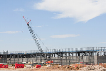 A crawler crane operates at the Meta Mesa Data Center construction site, where steel framing outlines one of five buildings in development for the tech giant’s expanding Arizona campus