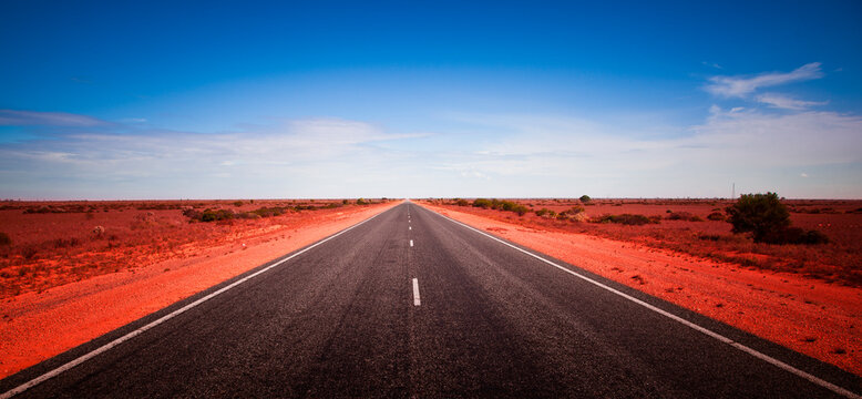 90 Mile Straight. Australia's longest straight road. Open road crossing the Nullarbor Plain in Western Australia. Long road stretching into the distance. Adventure Travel.