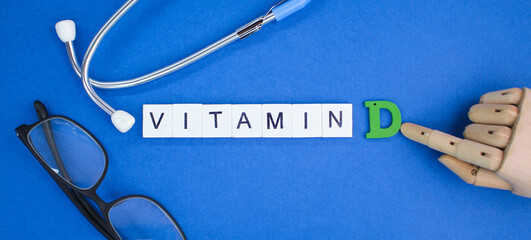 stethoscope and letters of the alphabet with the word vitamin D. vitamin d concept. soluble vitamin...
