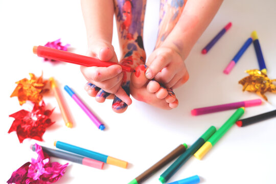 Child painting, coloring feet, barefoot. Having fun and creativity