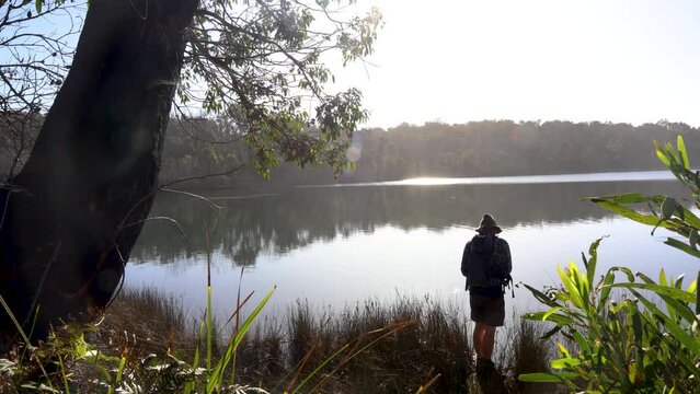 A man casts a fishing line into a calm peaceful estuary in Victoria Australia.