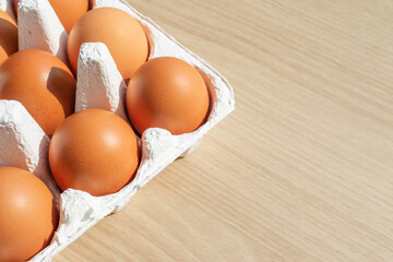 Fresh eggs in an egg carton.  warm sunshine