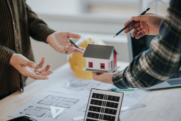 Engineer working in office at desk with solar laptop and concept home design Solar Renewable Energy Planning and wind turbine technology business successful work. © Witoon