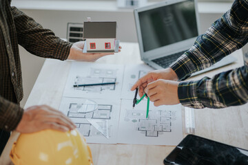 Engineer working in office at desk with solar laptop and concept home design Solar Renewable Energy Planning and wind turbine technology business successful work.