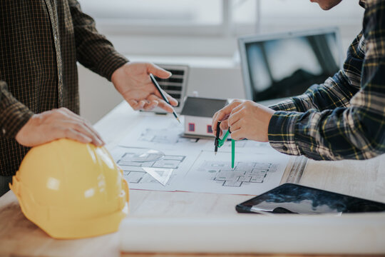 Engineer working in office at desk with solar laptop and concept home design Solar Renewable Energy Planning and wind turbine technology business successful work.