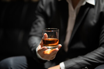 Businessman sitting Holding a Glass of Whiskey Drink Whiskey in the liquor store room