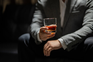 Businessman sitting Holding a Glass of Whiskey Drink Whiskey in the liquor store room