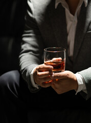 Businessman sitting Holding a Glass of Whiskey Drink Whiskey in the liquor store room