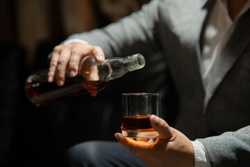 Fototapeta na wymiar Businessman sitting Holding a Glass of Whiskey Drink Whiskey in the liquor store room