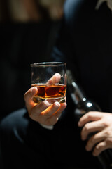 Businessman sitting Holding a Glass of Whiskey Drink Whiskey in the liquor store room