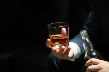 Businessman sitting Holding a Glass of Whiskey Drink Whiskey in the liquor store room