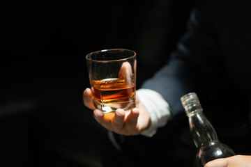 Businessman sitting Holding a Glass of Whiskey Drink Whiskey in the liquor store room