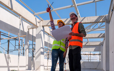 Caucasian engineer manager and foreman or leader discussion with woman engineering and pointing to construction site project on workplace . Teamwork, Leadership concept.