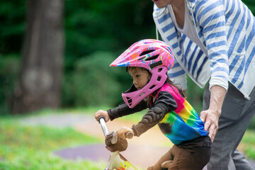 Father or coach supervises the little rider while training, with parent supervision