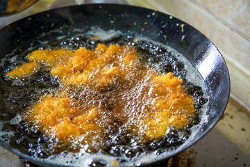 Delicious chicken chops are being fried in the kitchen oil pan