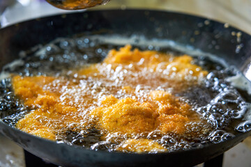 Delicious chicken chops are being fried in the kitchen oil pan