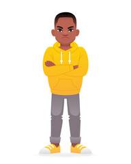 Displeased black little boy stands with his arms crossed. Cute african school kid in yellow hoodie.