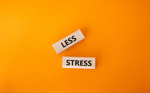 Less stress symbol. Wooden blocks with words Less stress. Beautiful orange background. Healthcare and Less stress concept. Copy space.