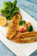 Grilled sea bass fillet served with garnishes in a fine dining restaurant
