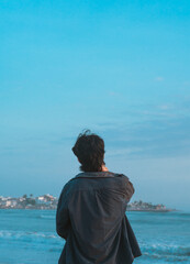 Person looking at a city from the shore of a beach - Persona mirando una ciudad desde la orilla de una playa