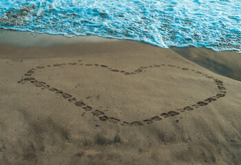 Heart made of footsteps in the sand of a beach - Corazón hecho de pasos en la arena de una playa