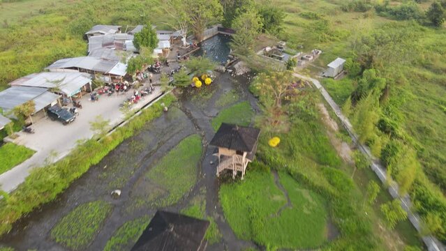 Aerial view of people in natural swimming pool in the midle of forest in Klaten, Indonesia