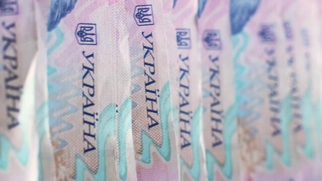 Vertical video. Money background. Ukrainian hryvnia. UAH currency. Closeup of 200 hrn bill pink blue color paper banknotes cash pile.