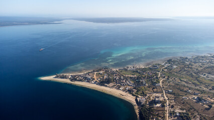 Aerial view of seaside town with blue waters and sandy beaches