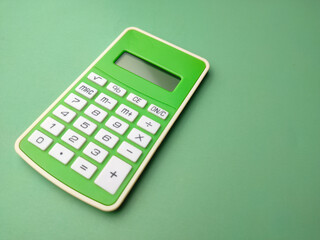 Closeup green calculator on a green background