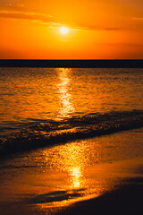 Reflection of sunlight over sea surface at sunset. Orange and gold blue sky. Scenic Gold sea....