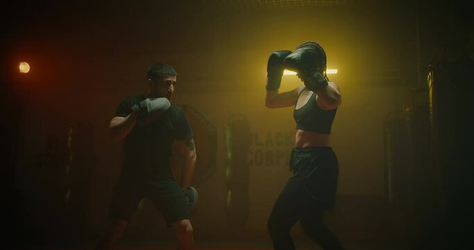 self-defense class for women, slender lady training with male coach in fitness club, 4K, Prores