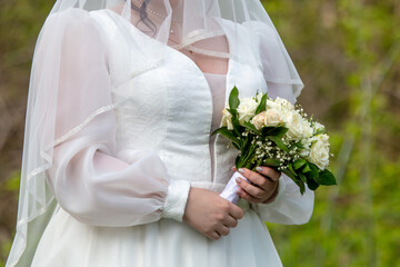 Bride in a white dress with a bouquet of flowers in her hands