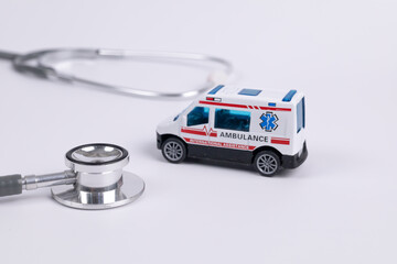 Close up gray stethoscope with ambulance car on white background for doctor and medical nursing people check up healing of patients in hospital. healthcare concept. emergency case.